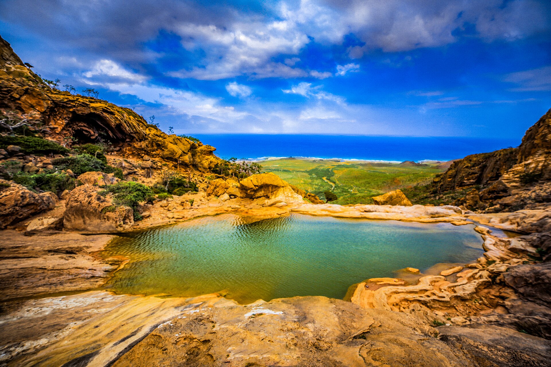 Paisagem árida de Socotorá com piscina natural e vista para o mar