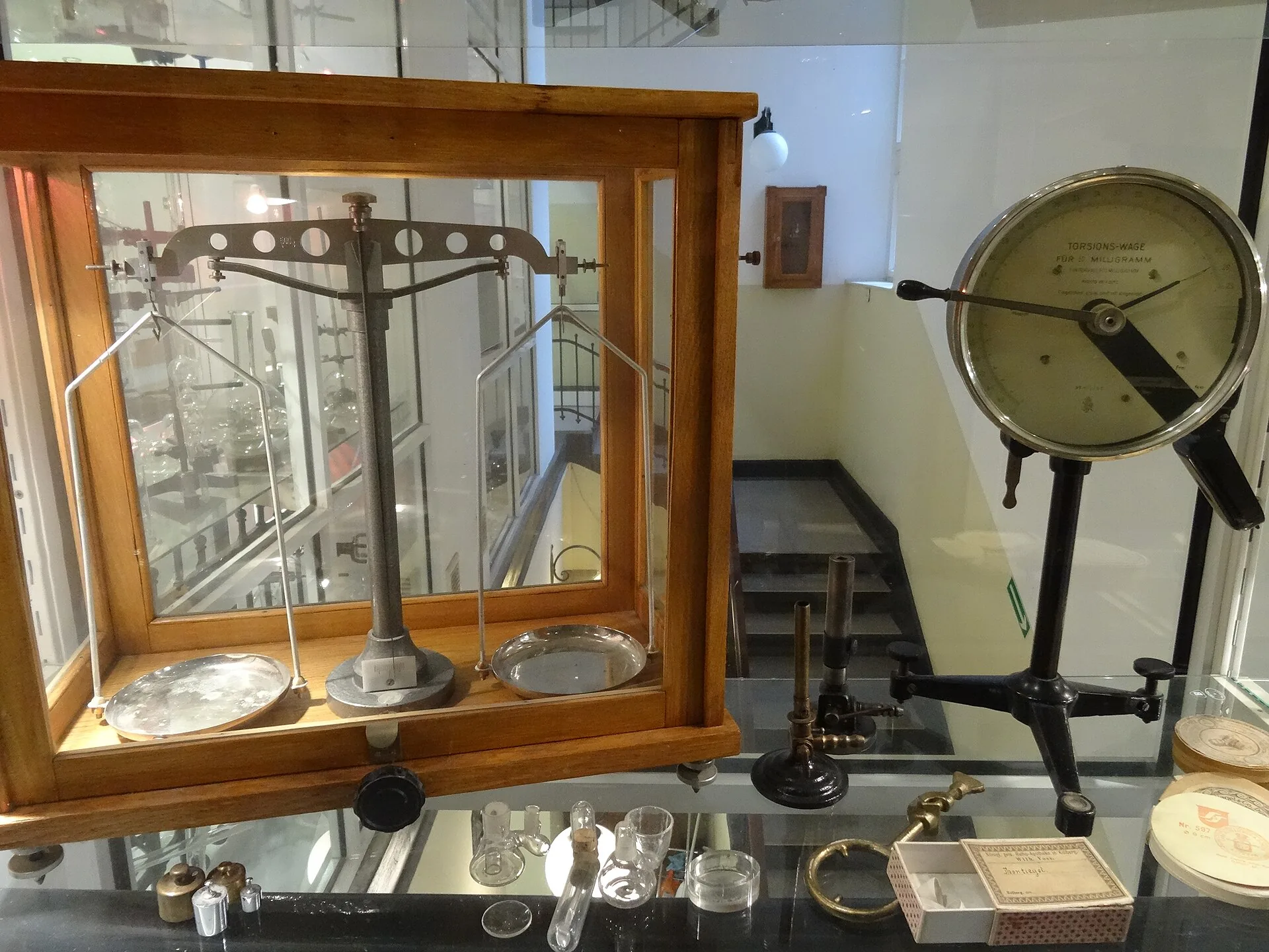 Balanças e instrumentos científicos antigos numa vitrina de laboratório